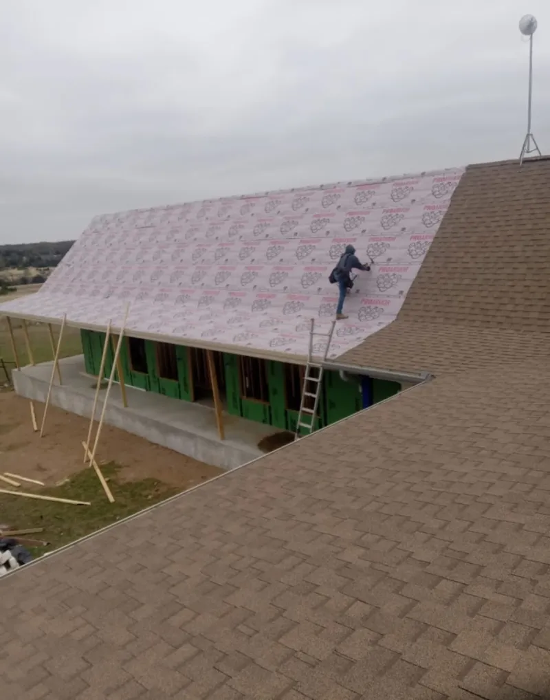 Worker preparing underlayment for a metal roof installation in Kingsport